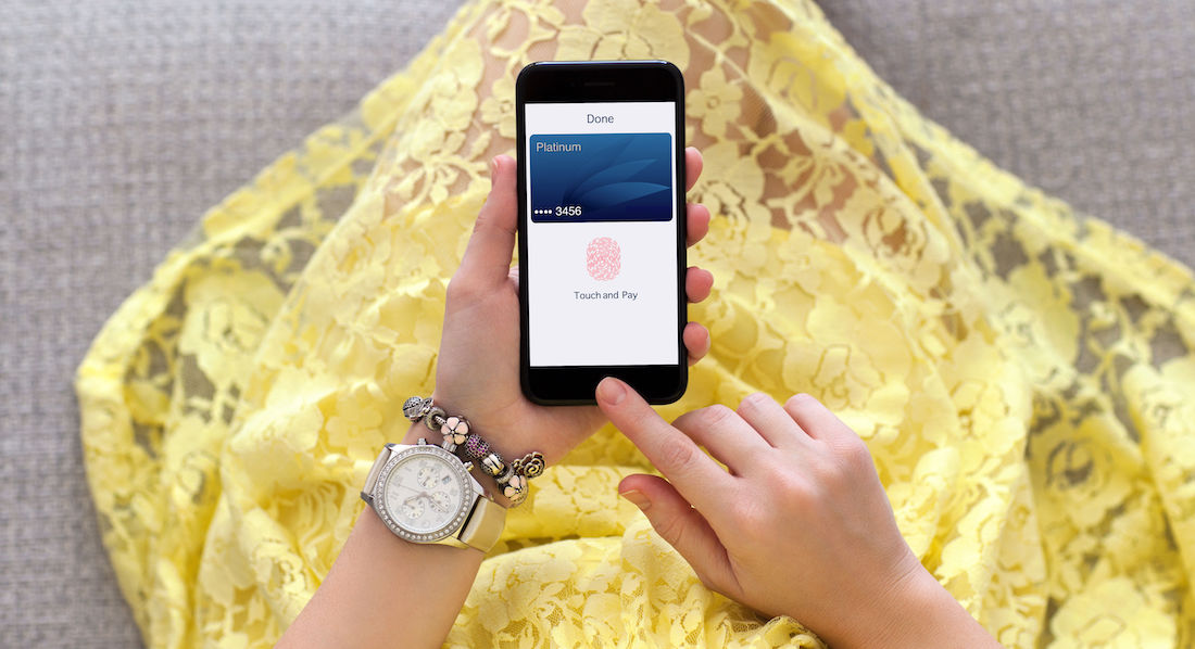 Frau öffnet eine Kreditkarten-App auf ihrem Smartphone per Fingerabdruck