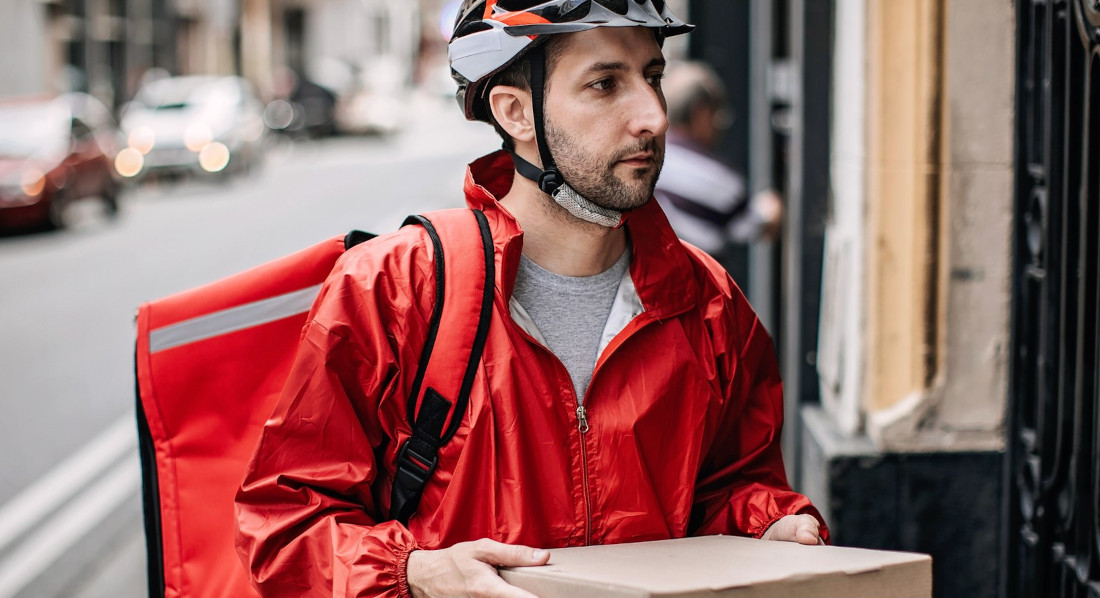 Ein Mann liefert eine Pizza an die Haustür