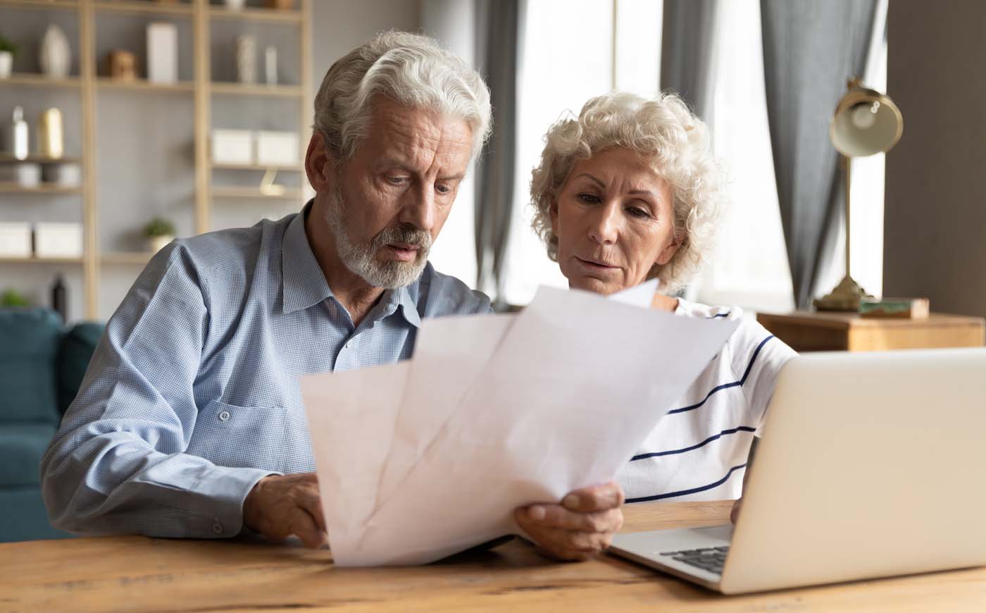 Älteres Paar liest aufmerksam Vertragsunterlagen