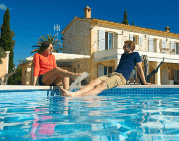 Paar sitzt planschend am Pool und unterhält sich über das TagesGeld der Hanseatic Bank