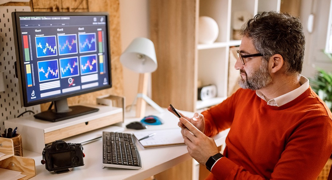 Ein Mann verfolgt zu Hause am Computer Kurven zur Wertentwicklung von Start-ups
