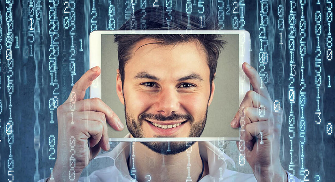 Mann hält sich ein Tablet vors Gesicht, das sein Gesicht zeigt