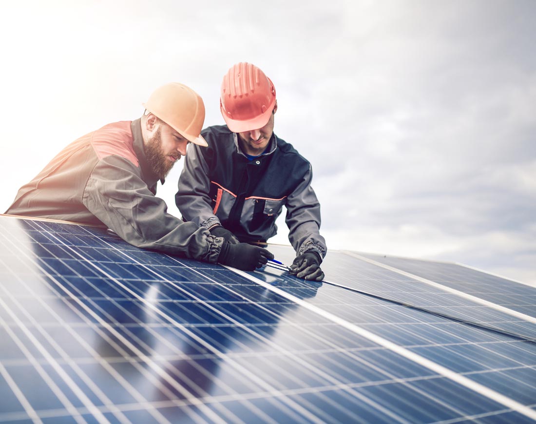 Arbeiter installieren eine Solaranlage auf einem Hausdach