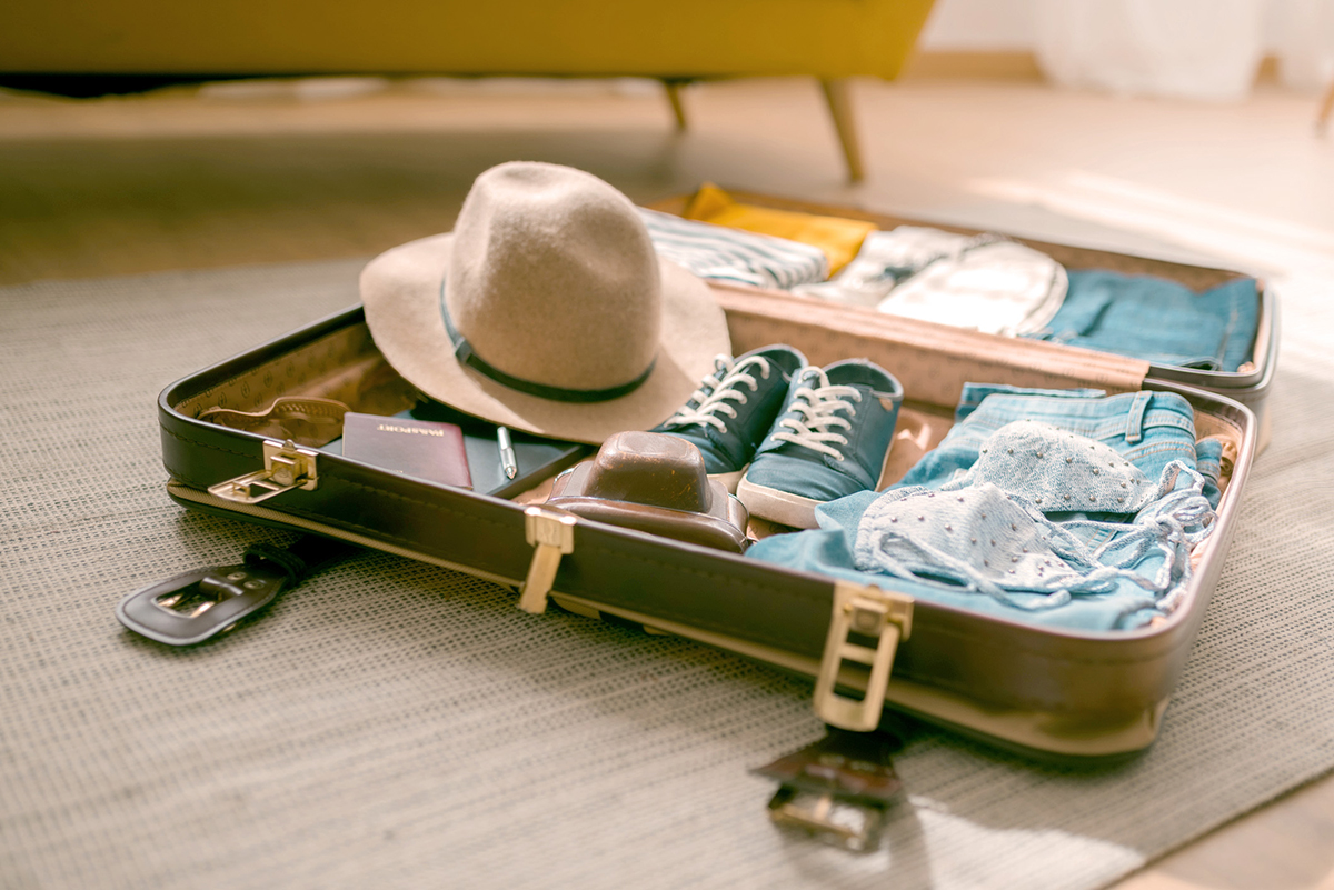 Gepackter Koffer mit Klamotten und Reisepass der symbolisch für die Reisewelt der Hanseatic Bank steht