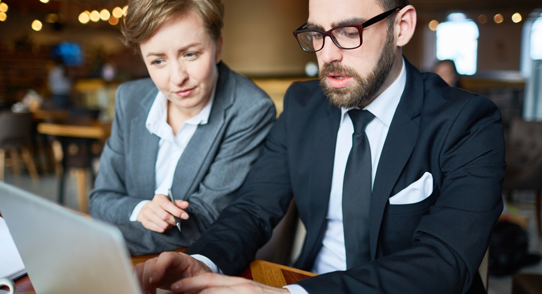 Arbeitgeber und Arbeitnehmerin sitzen gemeinsam vor einem Laptop und vereinbaren die Entgeltumwandlung für die betriebliche Altersvorsorge