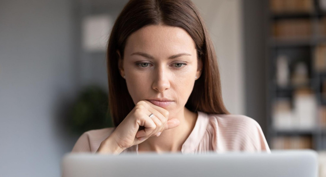 Frau blickt auf den Bildschirm ihres Laptops