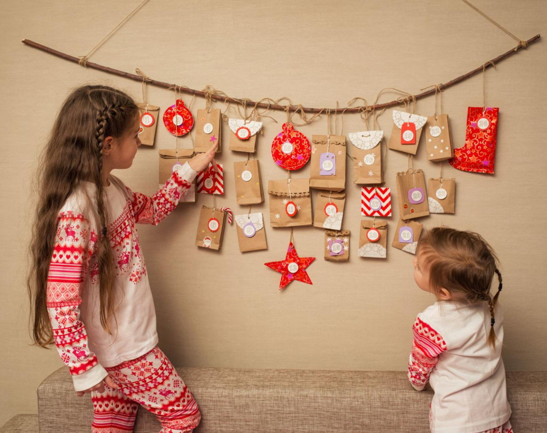 Zwei Mädchen stehen vor einem selbstgebastelten Adventskalender