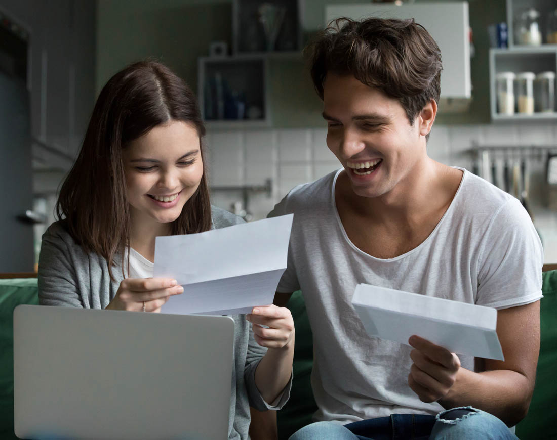 Junges Paar freut sich über den Gehaltszettel nach Eintrag einer Lohnsteuerermäßigung