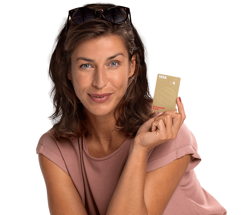 Lächelnde Frau im Sommer-Outfit zeigt die Hanseatic Bank GoldCard Kreditkarte hoch