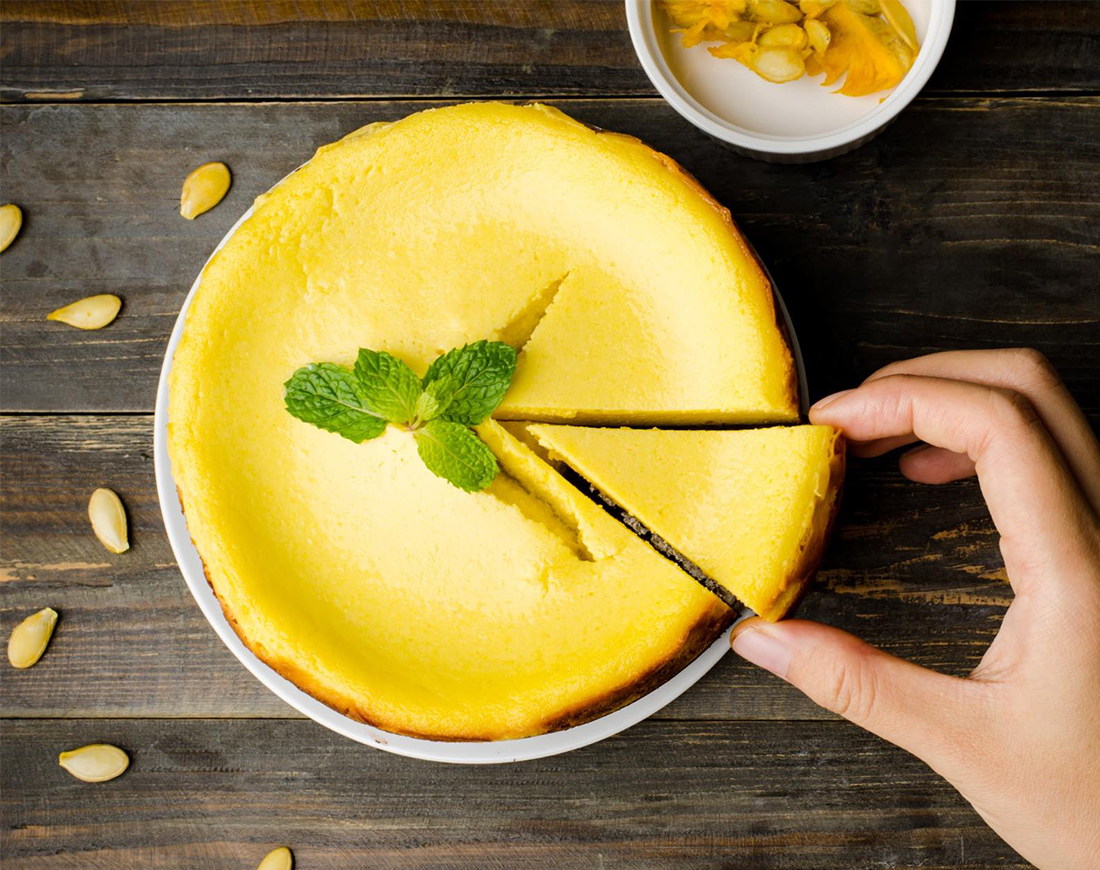 Hand greift nach einem Stück aus einer Torte