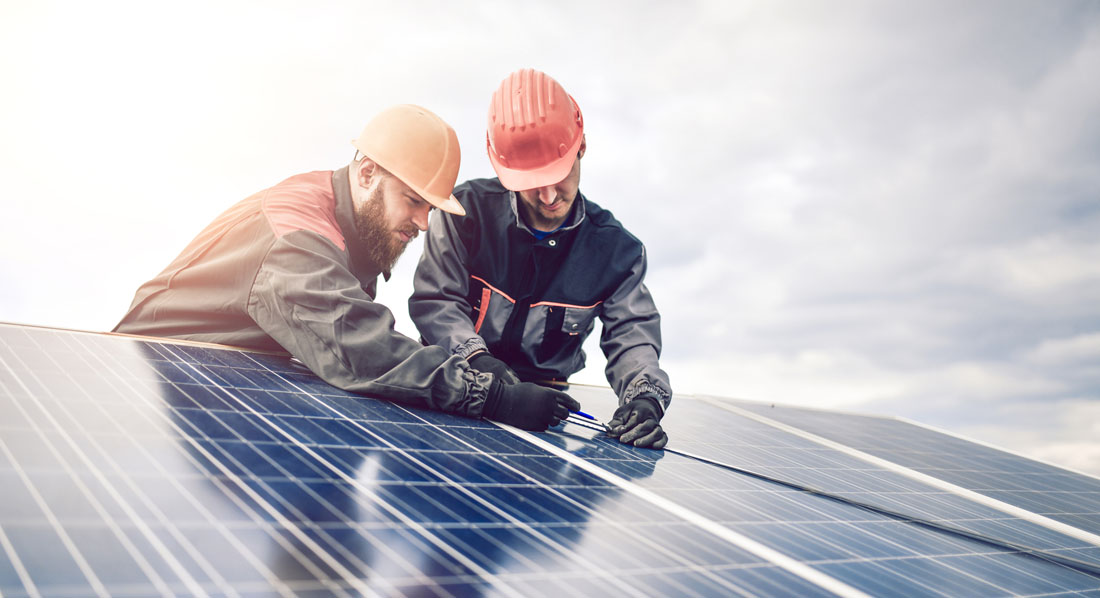 Arbeiter installieren eine Solaranlage auf einem Hausdach