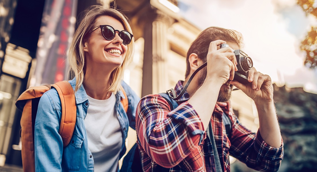 Ein Paar lacht und macht Urlaubsfotos.