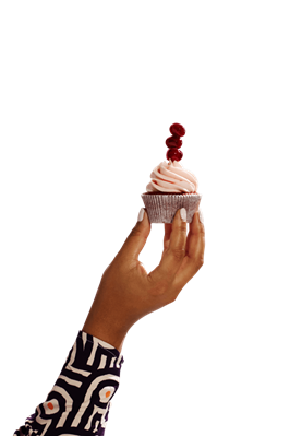 Hand, die einen Cupcake mit Creme und Kirschen hochhält