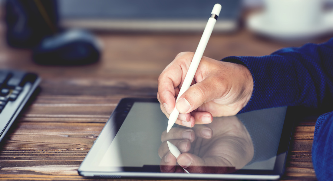 Mann schreibt mit Stift auf einem Tablet