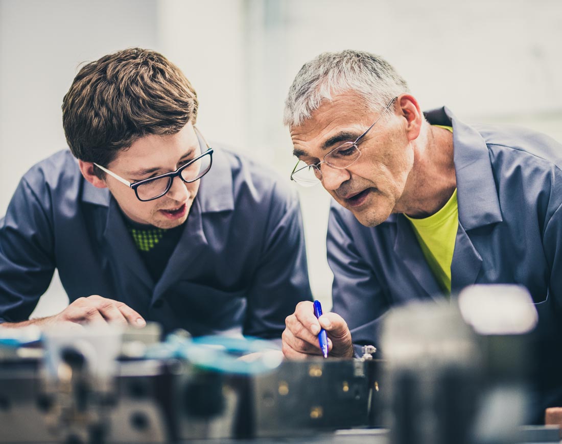 Ingenieur erklärt seinem Schüler die Funktionsweise einer Maschine