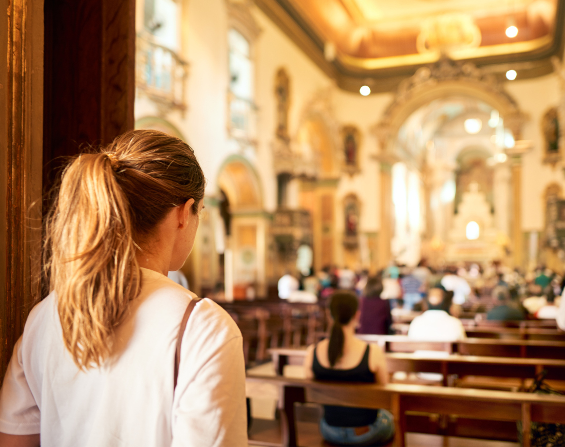 Eine Frau betritt eine hell erleuchtete Kirche
