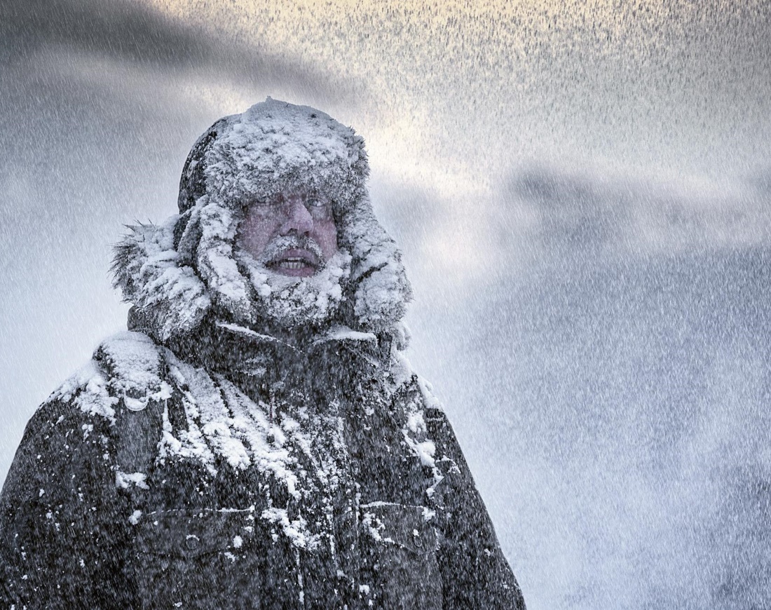 Dick vermummter Mann im Schneesturm