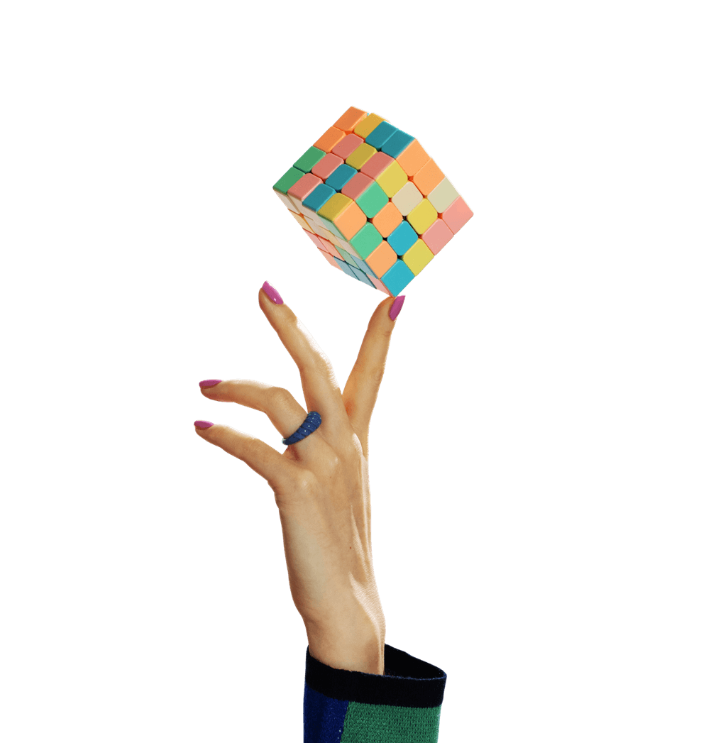 Hand balanciert einen bunten Wuerfel.png