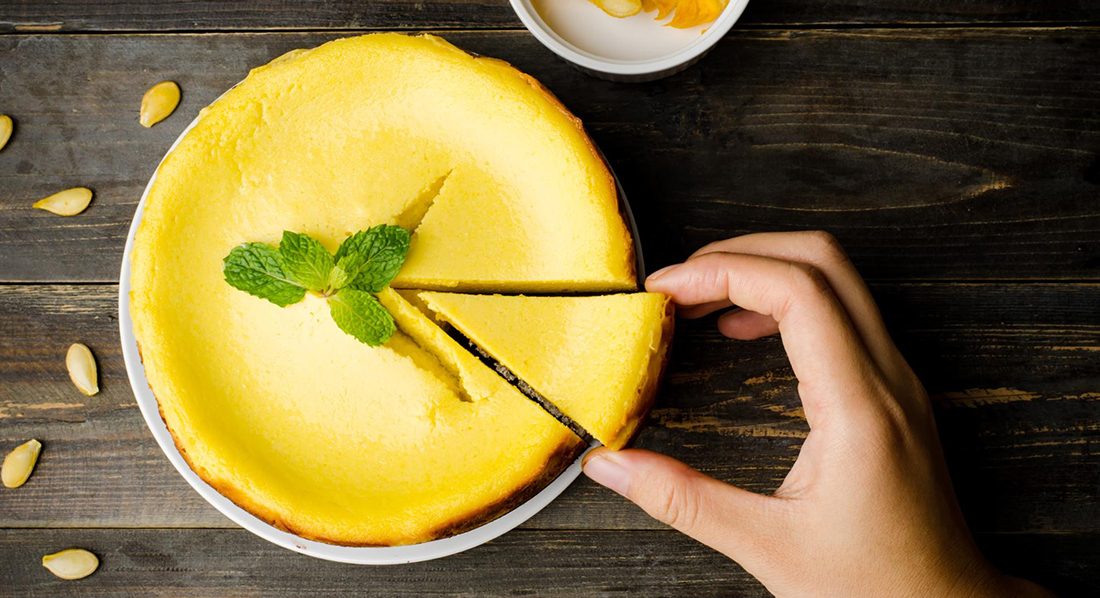 Hand greift nach einem Stück aus einer Torte