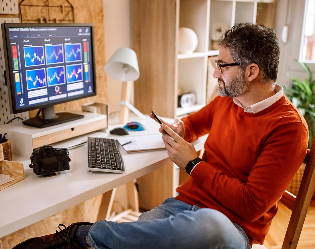 Ein Mann verfolgt zu Hause am Computer Kurven zur Wertentwicklung von Start-ups