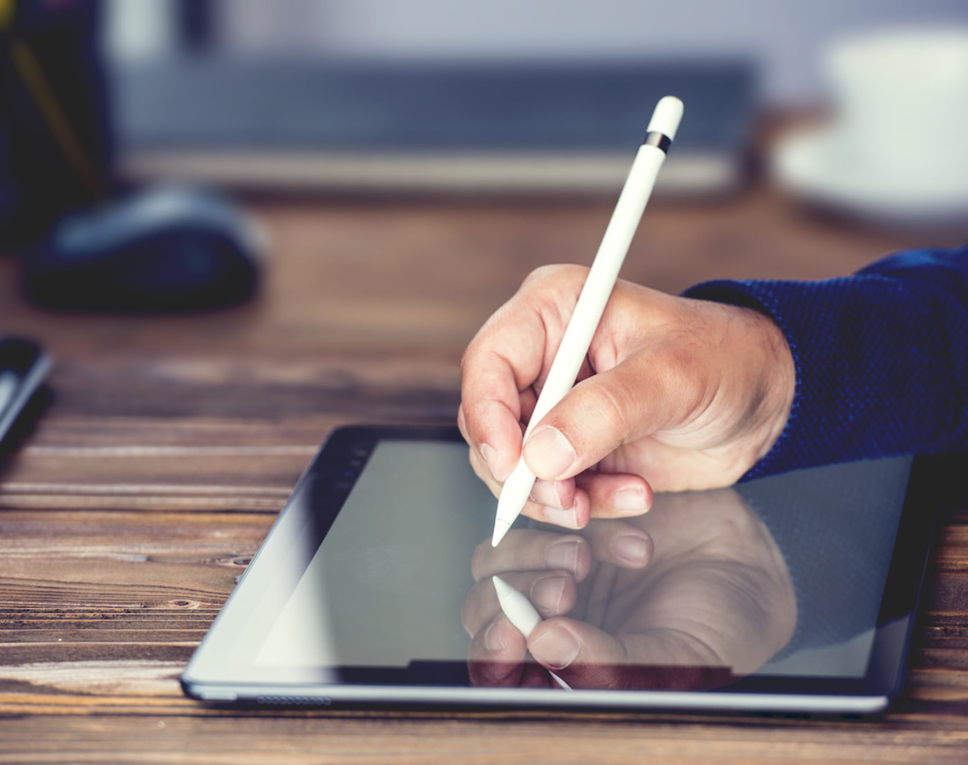 Mann schreibt mit Stift auf einem Tablet
