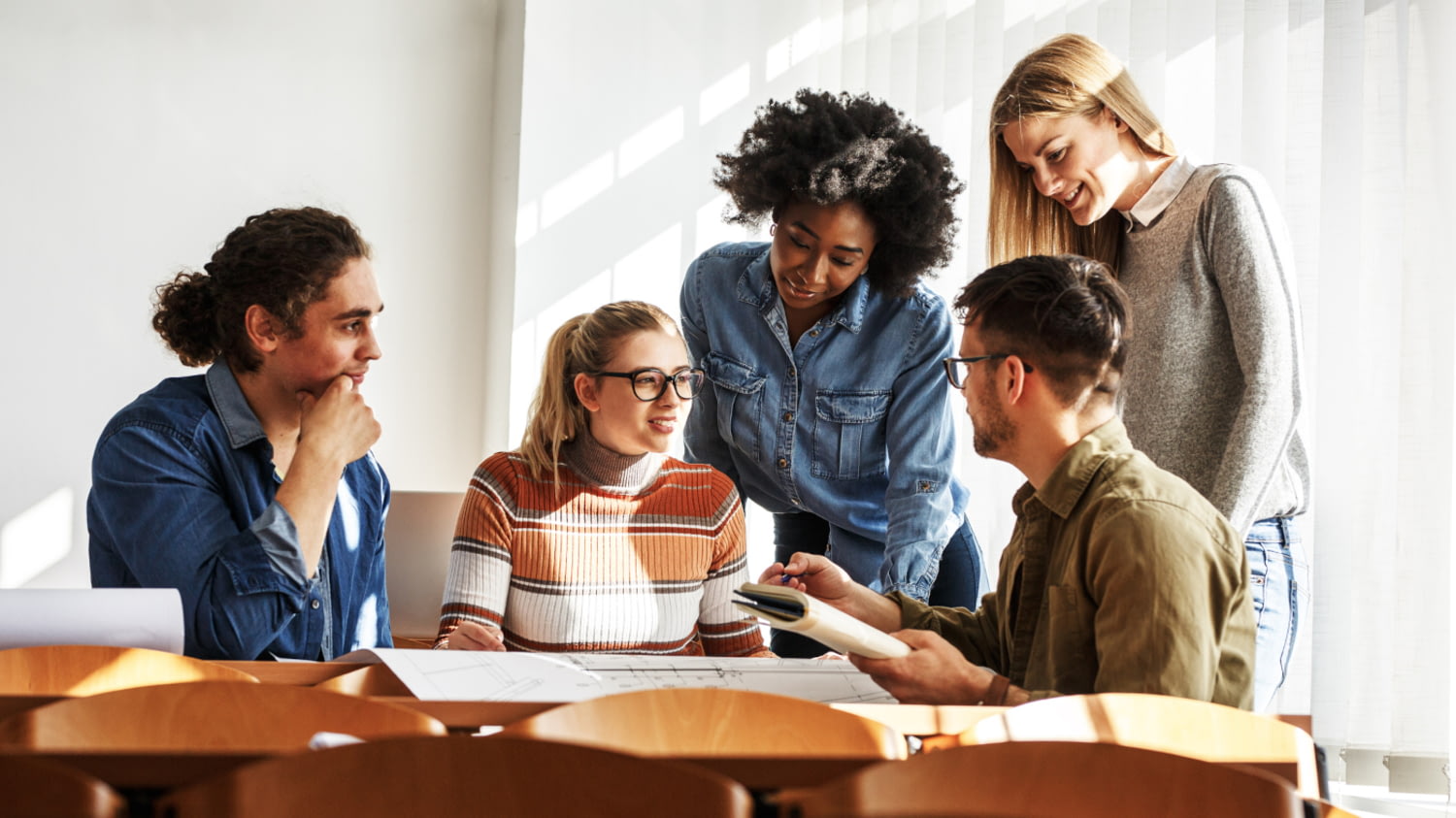 Eine Gruppe von fünf Studierenden diskutiert im Seminarraum