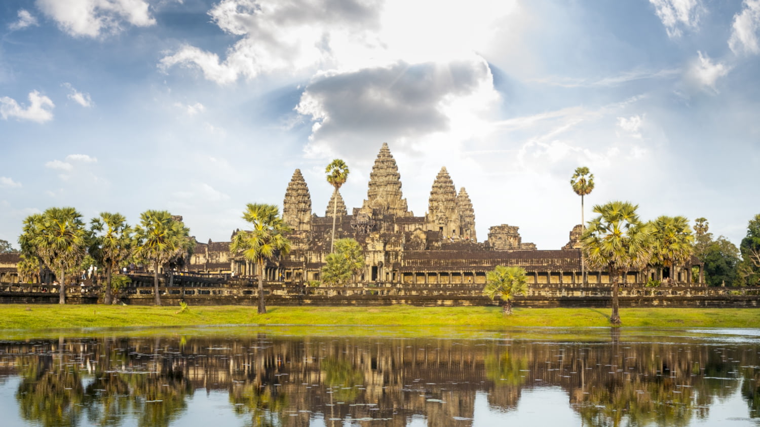 Ansicht des Tempels Angkor Wat in Kambodscha, der sich im Wassergraben vor der Anlage spiegelt