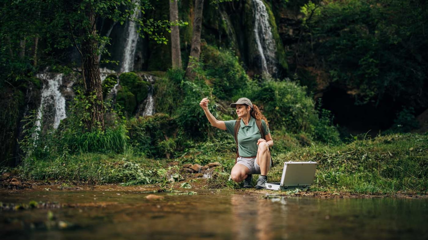 Frau nimmt Wasserprobe im Wald