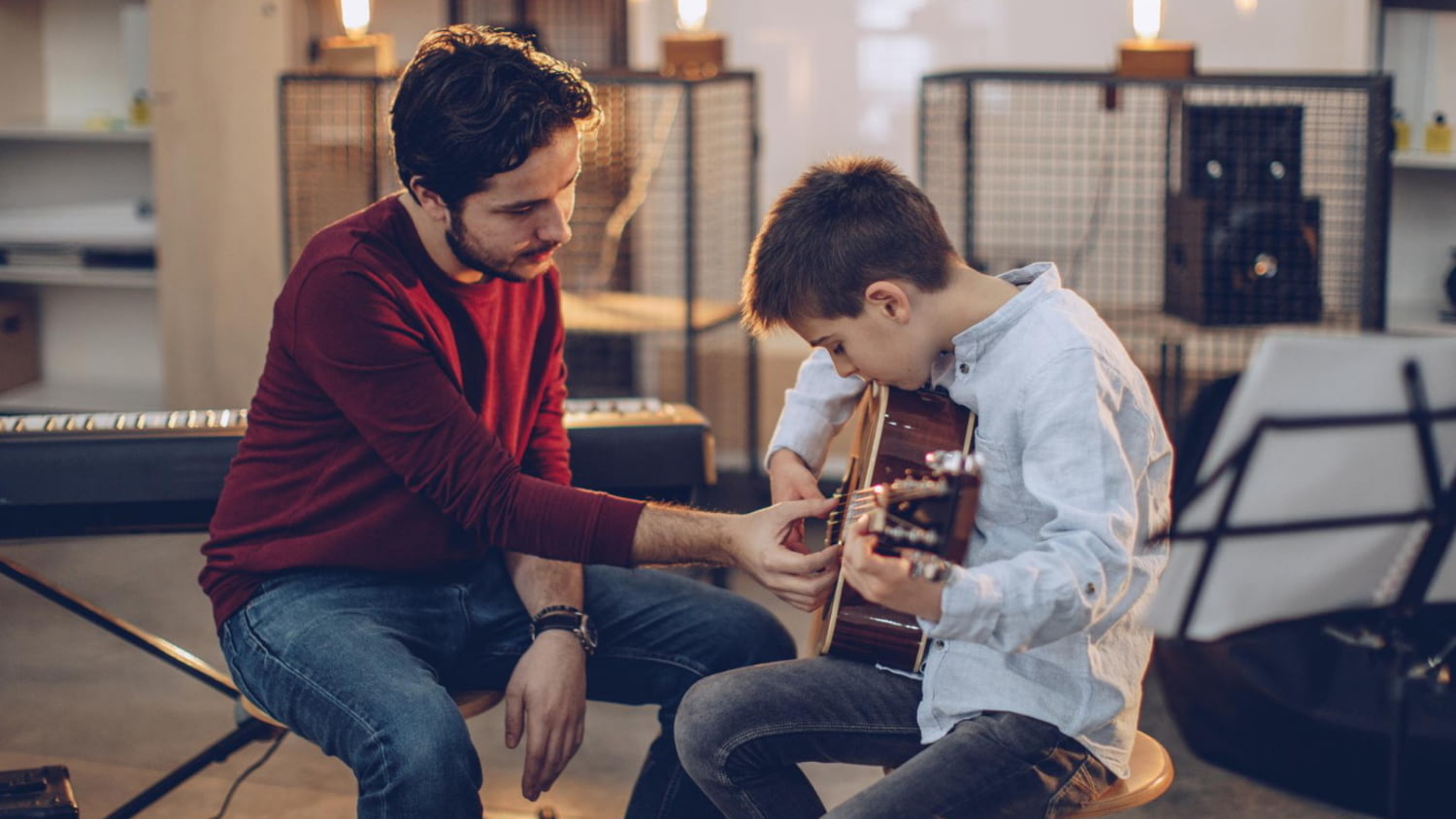 Freiberuflicher Gitarrenlehrer unterrichtet einen Jungen