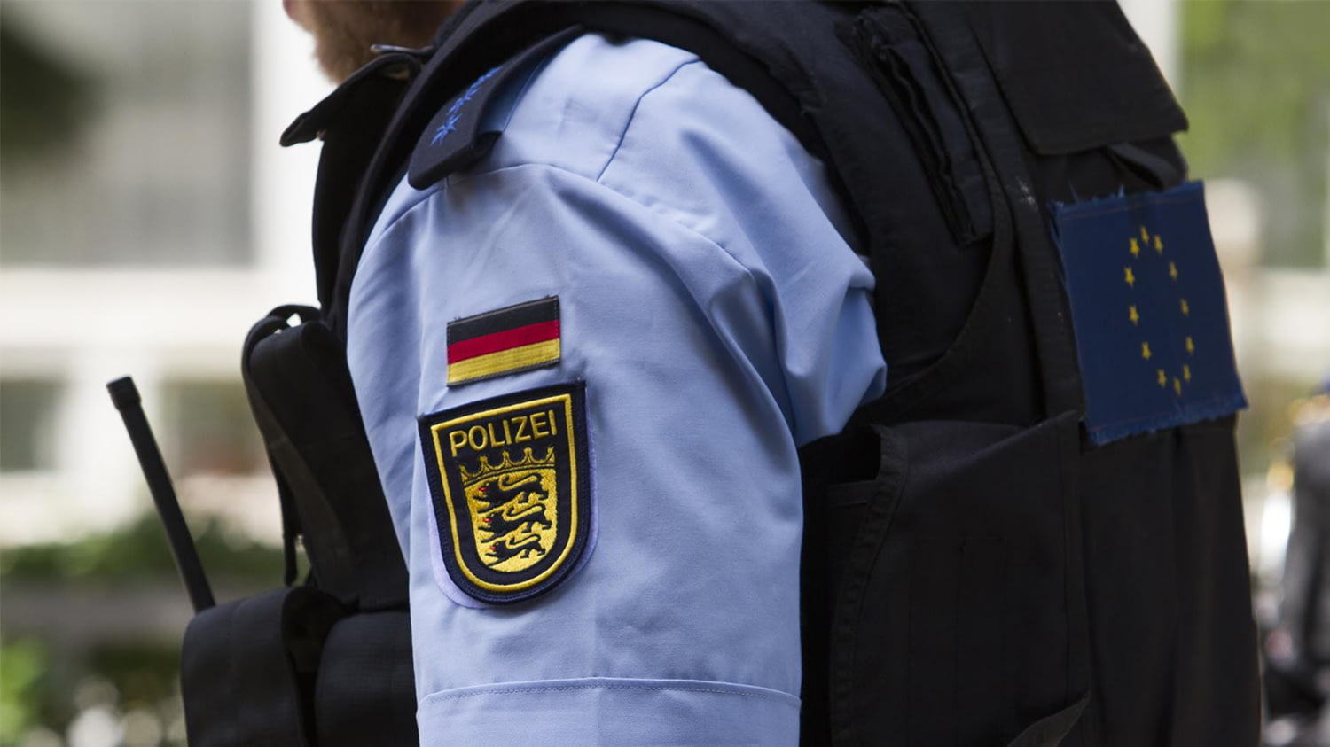 Ein Polizist mit Schutzweste und Walkie-Talkie