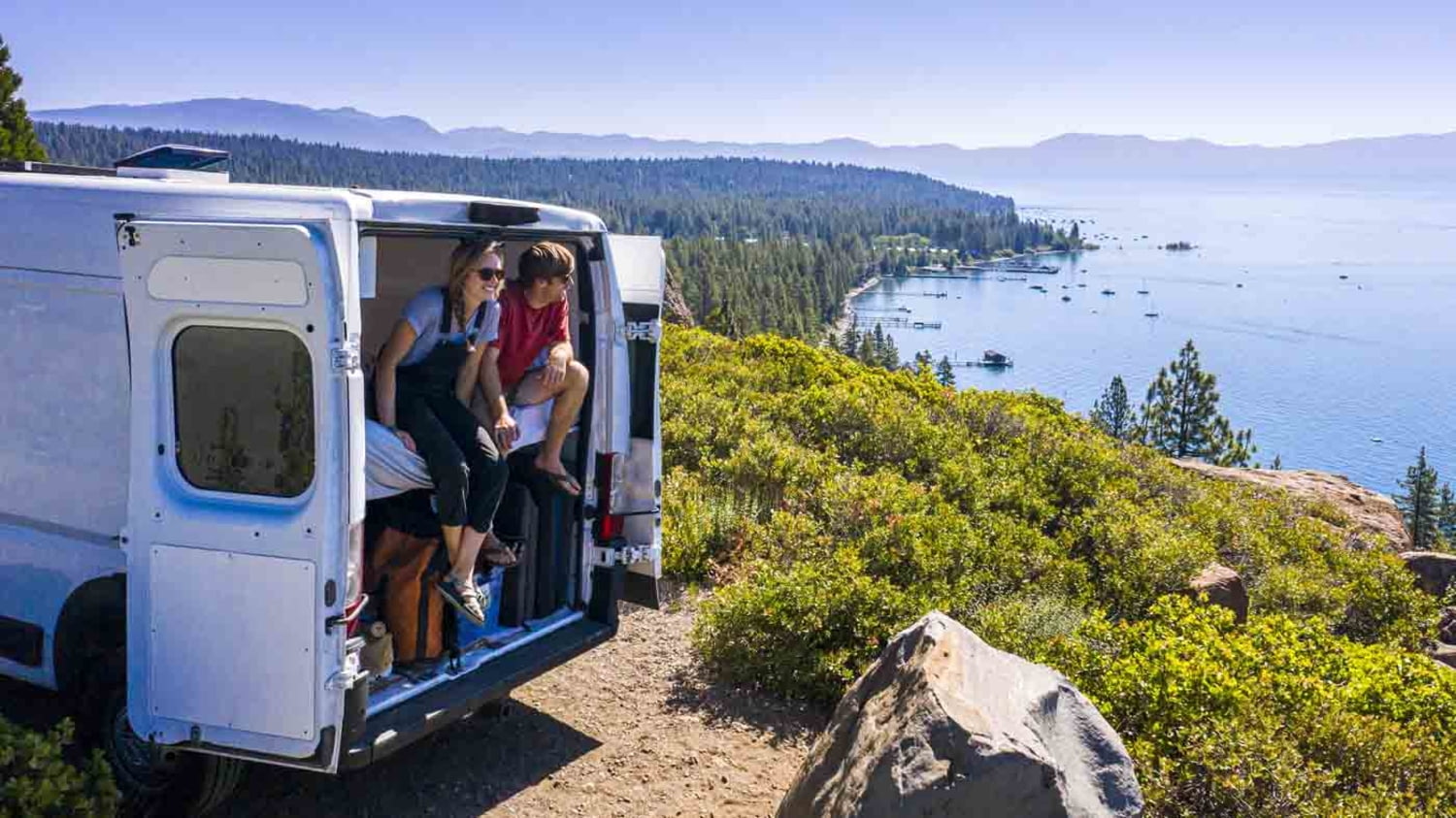 junges Paar sitzt in seinem Van und genießt den spektakulären Ausblick auf den Lake Tahoe