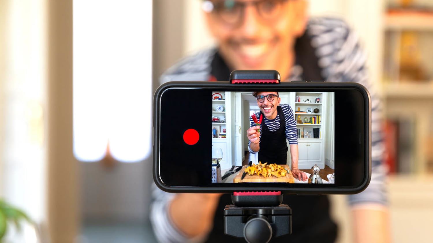 Ein Vlogger filmt sich beim Kochen mit einem Smartphone