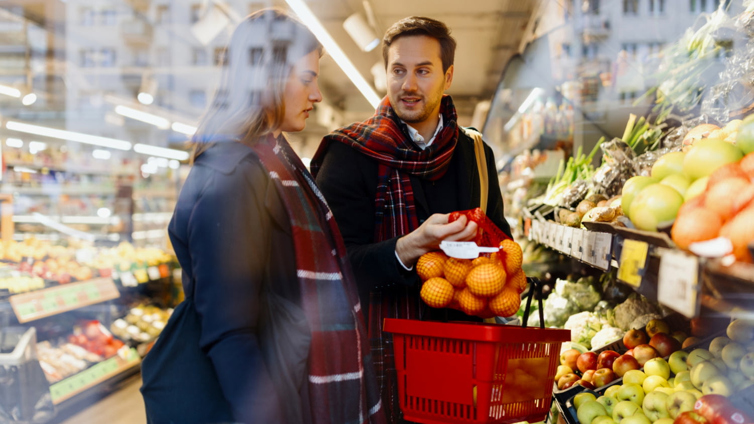 Eine Frau und ein Mann kaufen gemeinsam in einem Supermarkt Lebensmittel ein