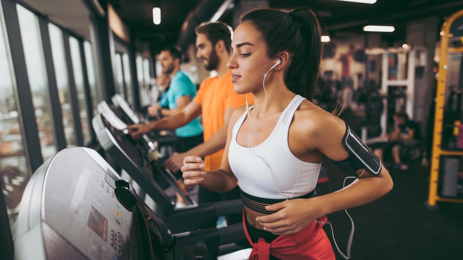 Junge Frau trainiert im Fitnessstudio auf dem Laufband