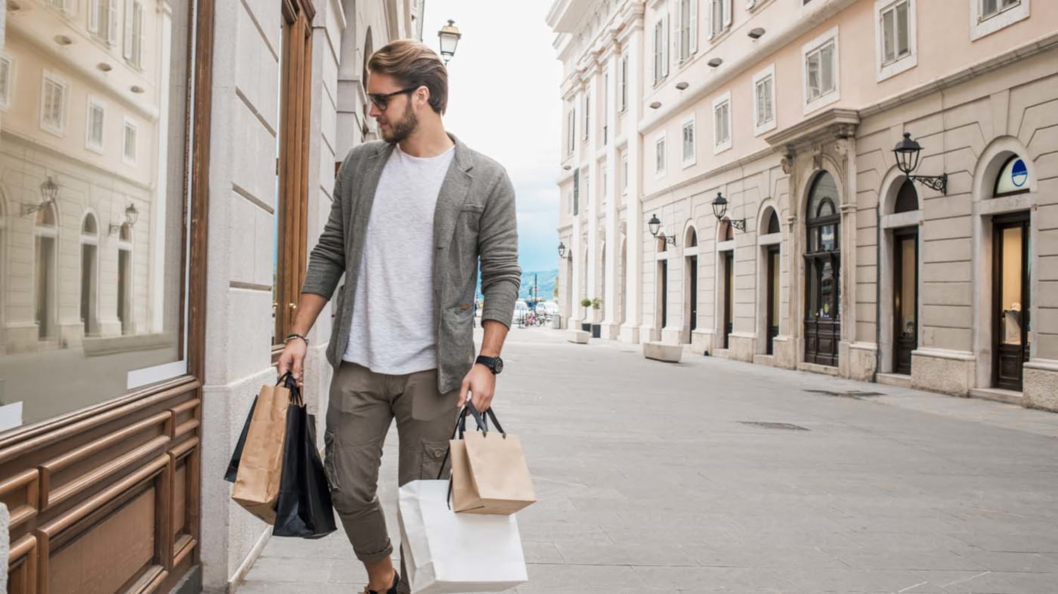 Mann trägt viele Shoppingtüten