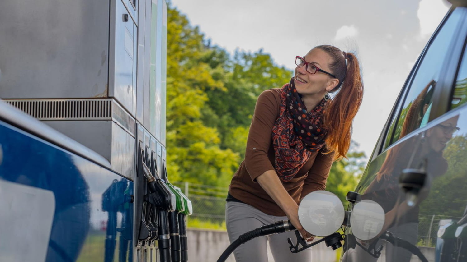 Eine Frau beim Tanken ihres Autos