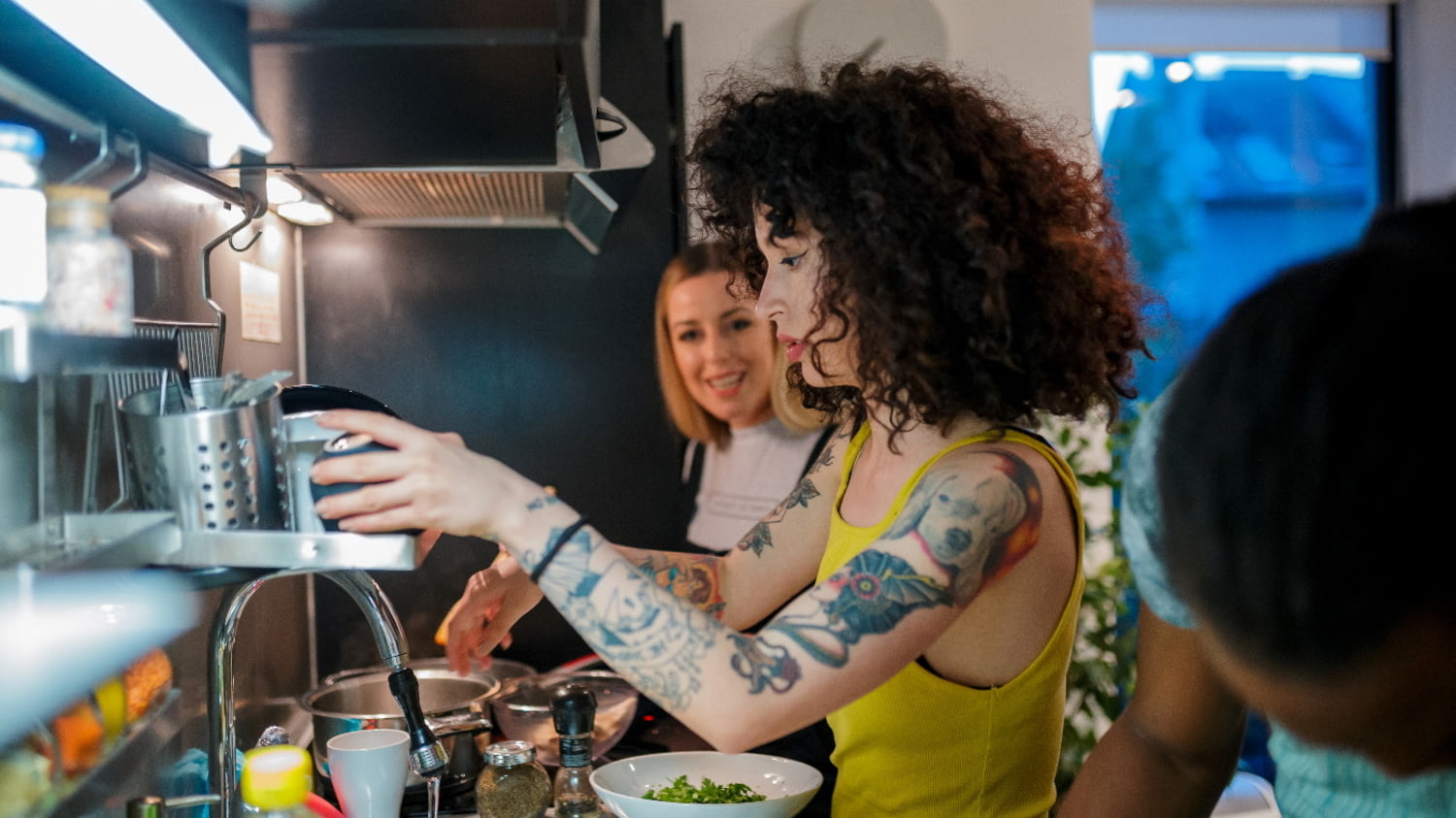 Drei junge Studenten kochen gemeinsam in einer WG-Küche