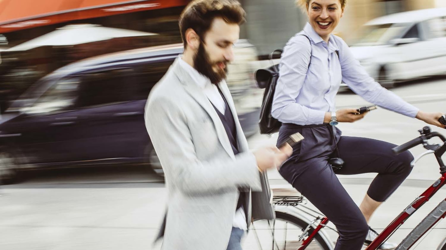 Fahrradfahrerin überholt Fußgänger im Businessoutfit