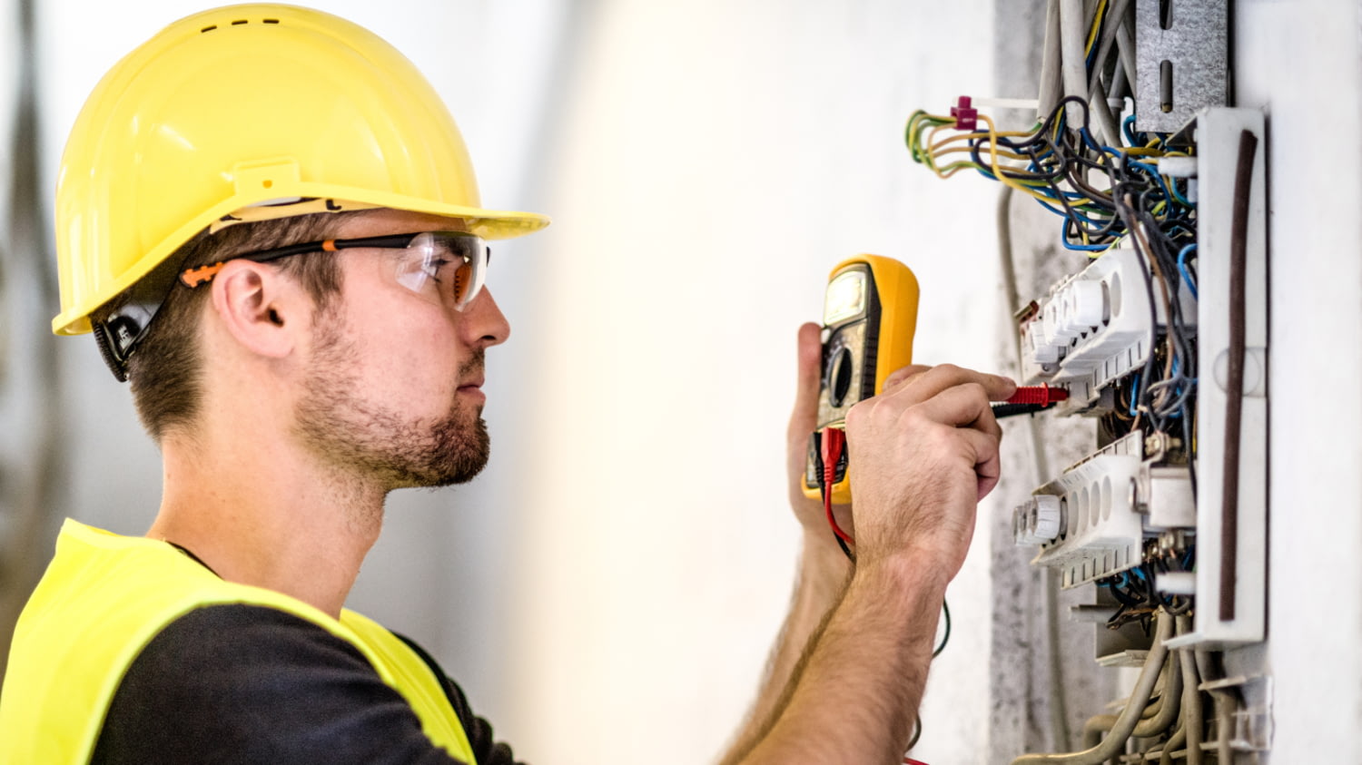 Elektriker kontrolliert die Anschlüsse in einem Sicherungskasten