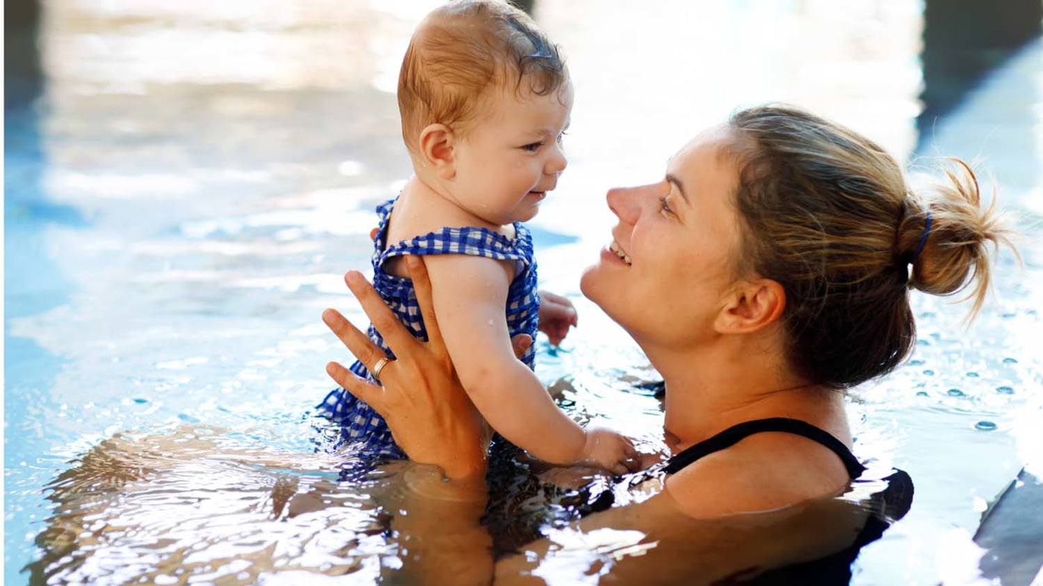 Eine Mutter schwimmt mit ihrem Kleinkind