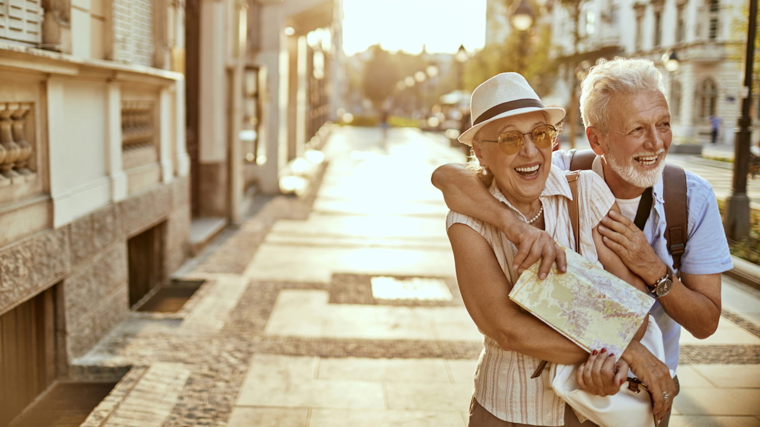 Lachendes Seniorenpaar spaziert im Urlaub durch eine Altstadt