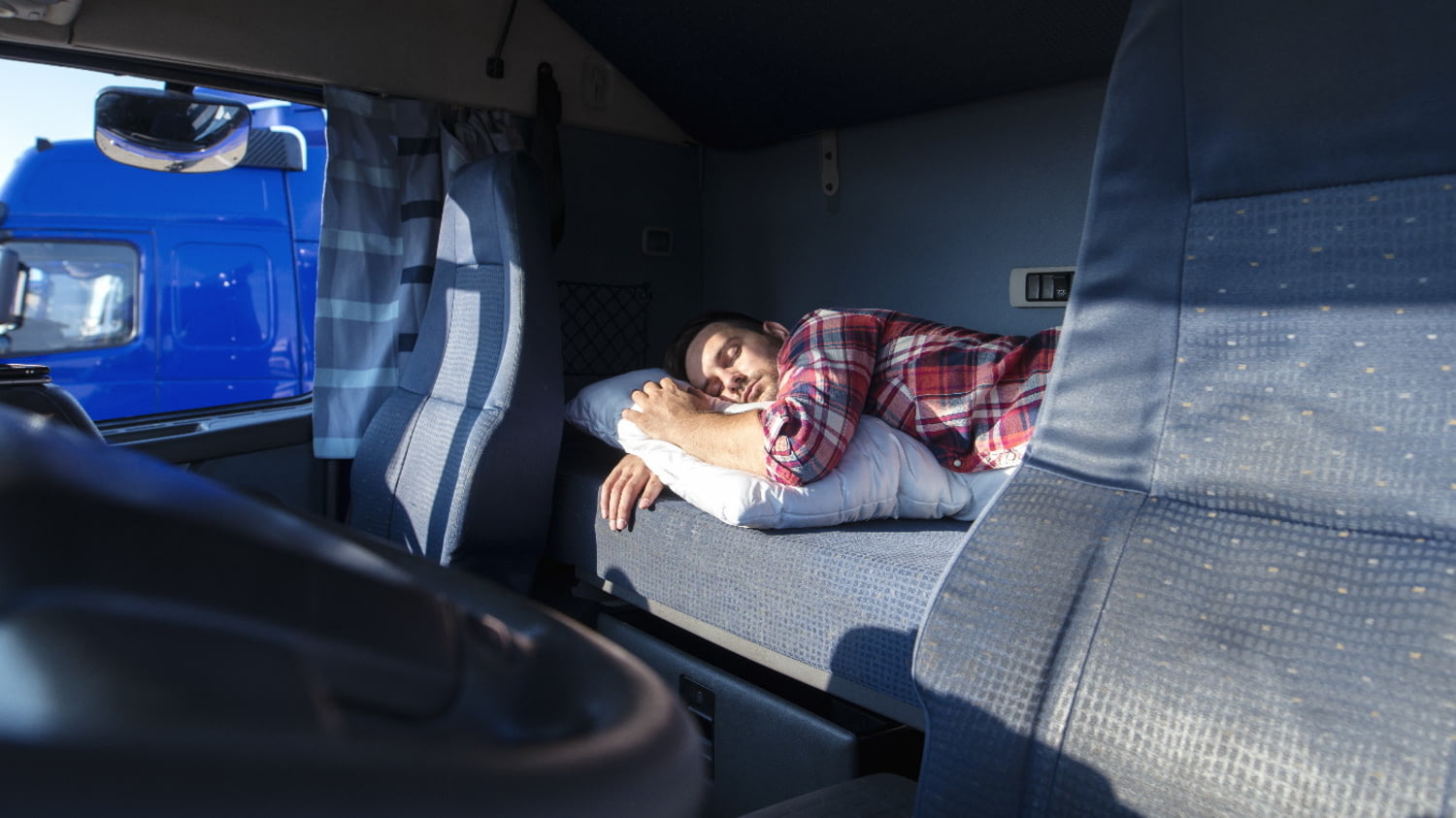 Trucker schläft auf der Rückbank seines LKW