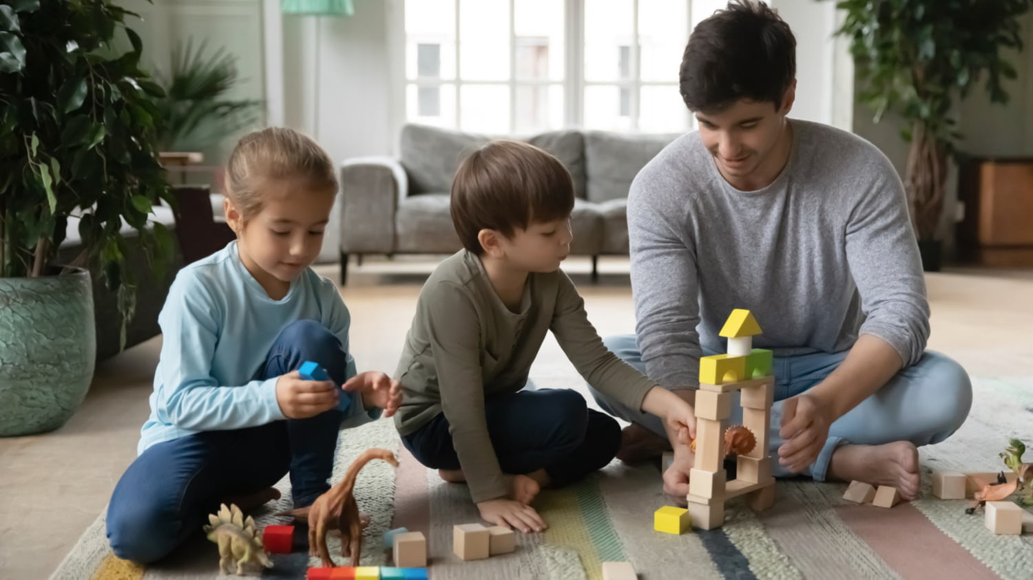 Ein Kinderbetreuer spielt mit einem Mädchen und Jungen