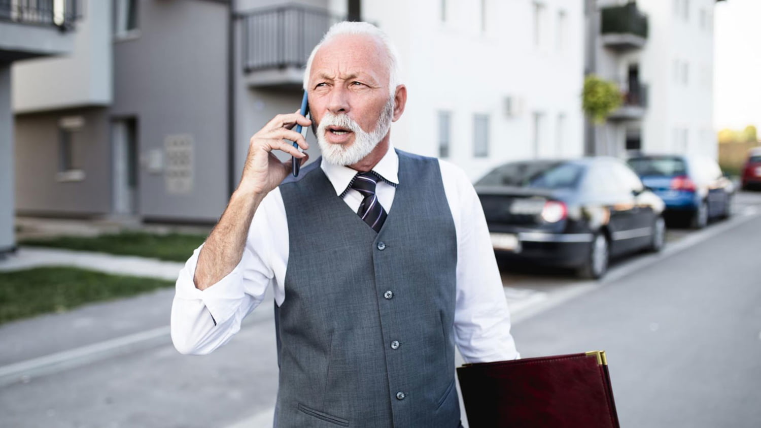 Senior telefoniert im Anzug, um eine Wohnung zu vermieten