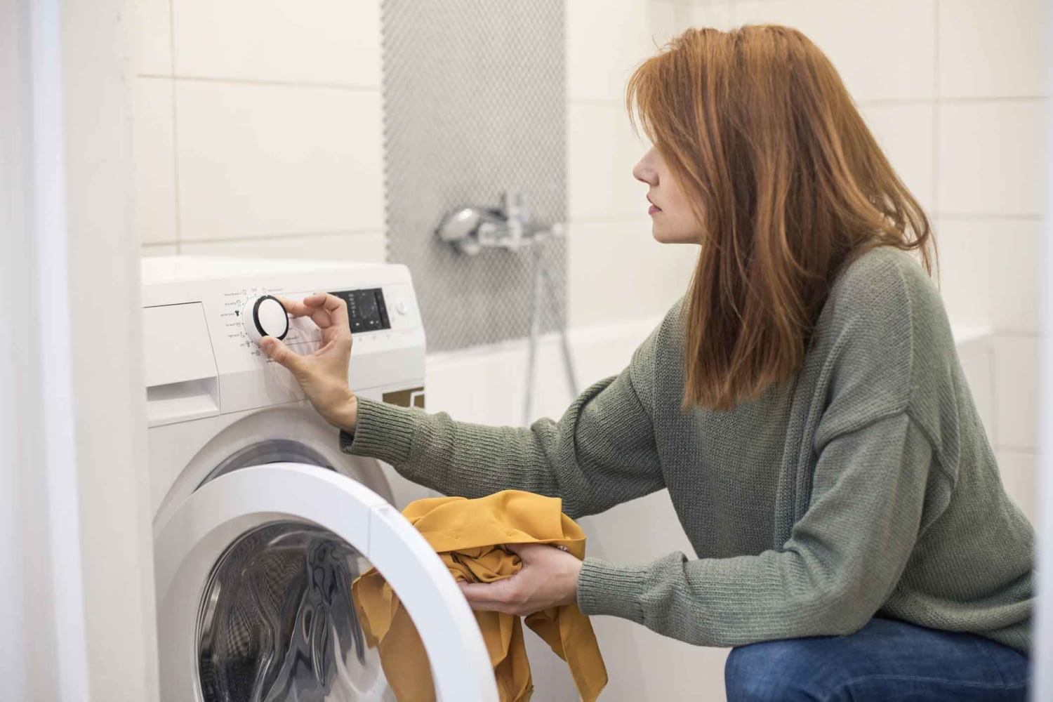 Eine junge Frau bedient die Waschmaschine