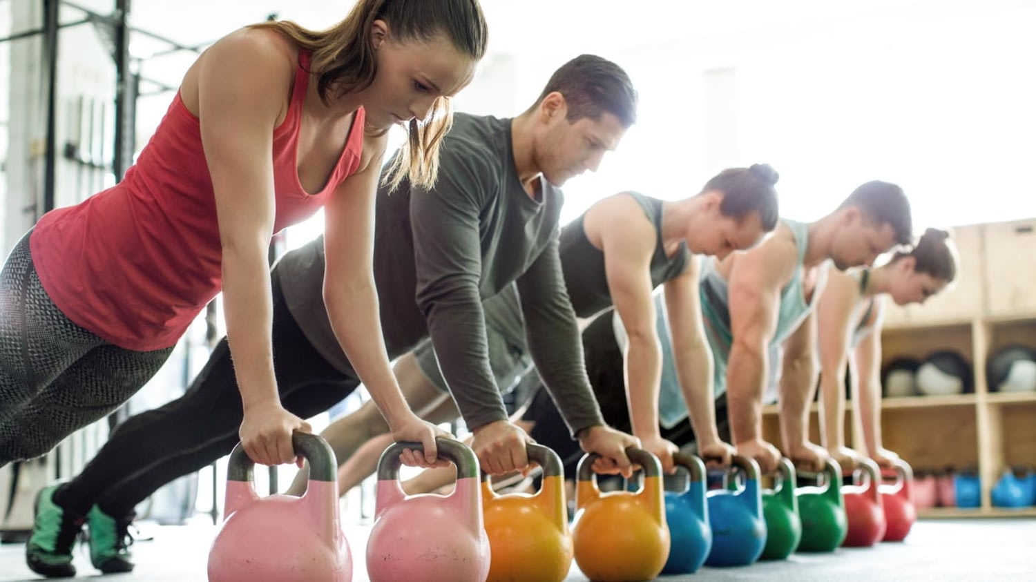 Sportliche junge Leute beim Training mit Kettlebells