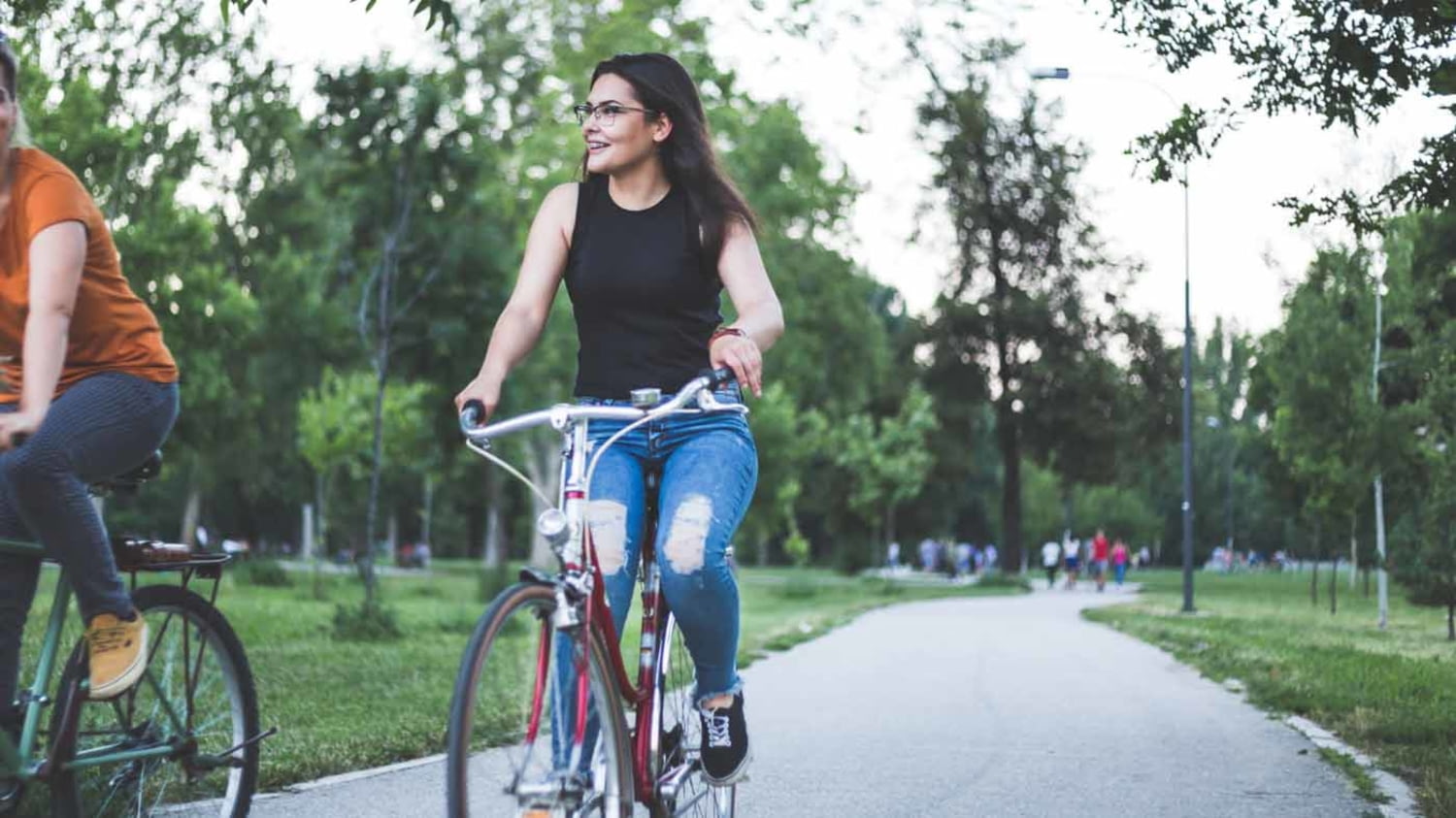 Zwei Menschen fahren in einem Park Fahrrad