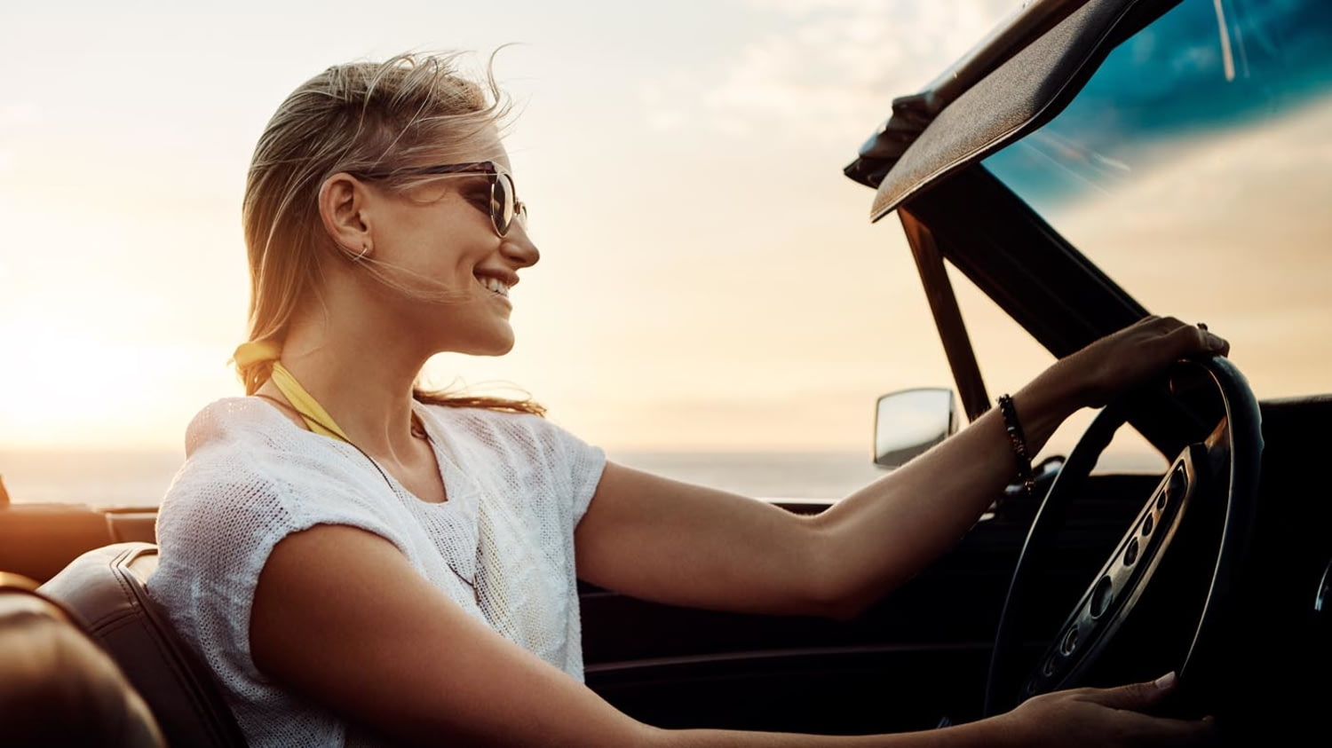 Eine Frau fährt im offenen Cabrio