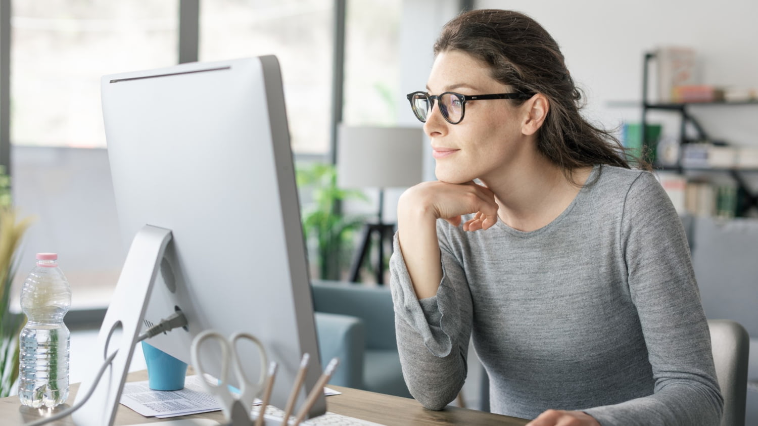 Junge Frau bei der entspannten Recherche am Computer