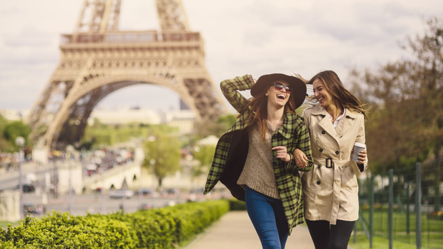 Zwei junge Frauen genießen einen Spaziergang vor dem Eiffelturm